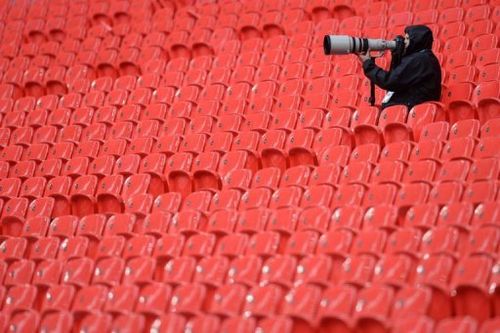 A photographer sits in the stands following a Bayern Munich training session at Wembley Stadium in London, May 24, 2013