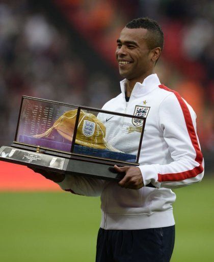 England defender Ashley Cole carries his golden cap at Wembley Stadium in north London on May 29, 2013