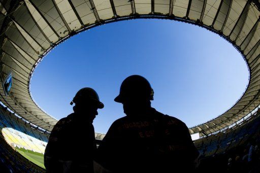 Workers are silhouetted at the Maracana stadium in Rio de Janeiro, Brazil on May 15, 2013