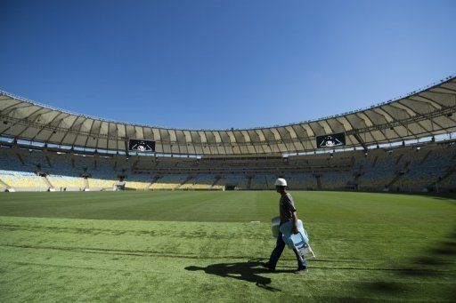 A worker walks across the pitch at the Maracana football stadium in Rio de Janeiro, on May 15, 2013