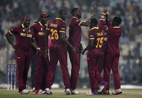 West Indian players celebrate after taking a wicket during the warm-up match against India