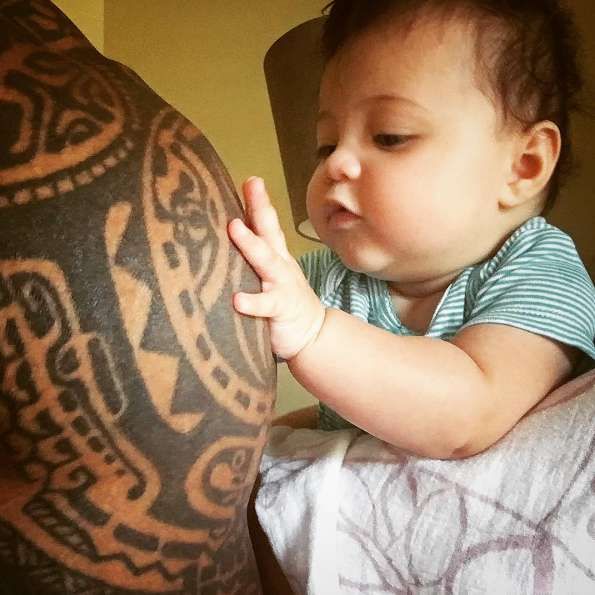 Jasmine loves playing with her dad’s tattoos!